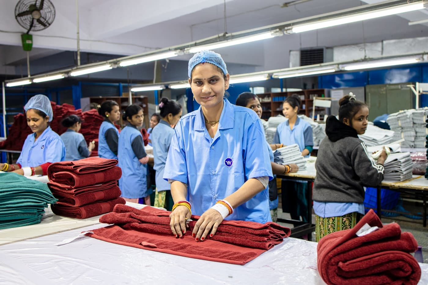 Production floor with workers stitching and folding fabric